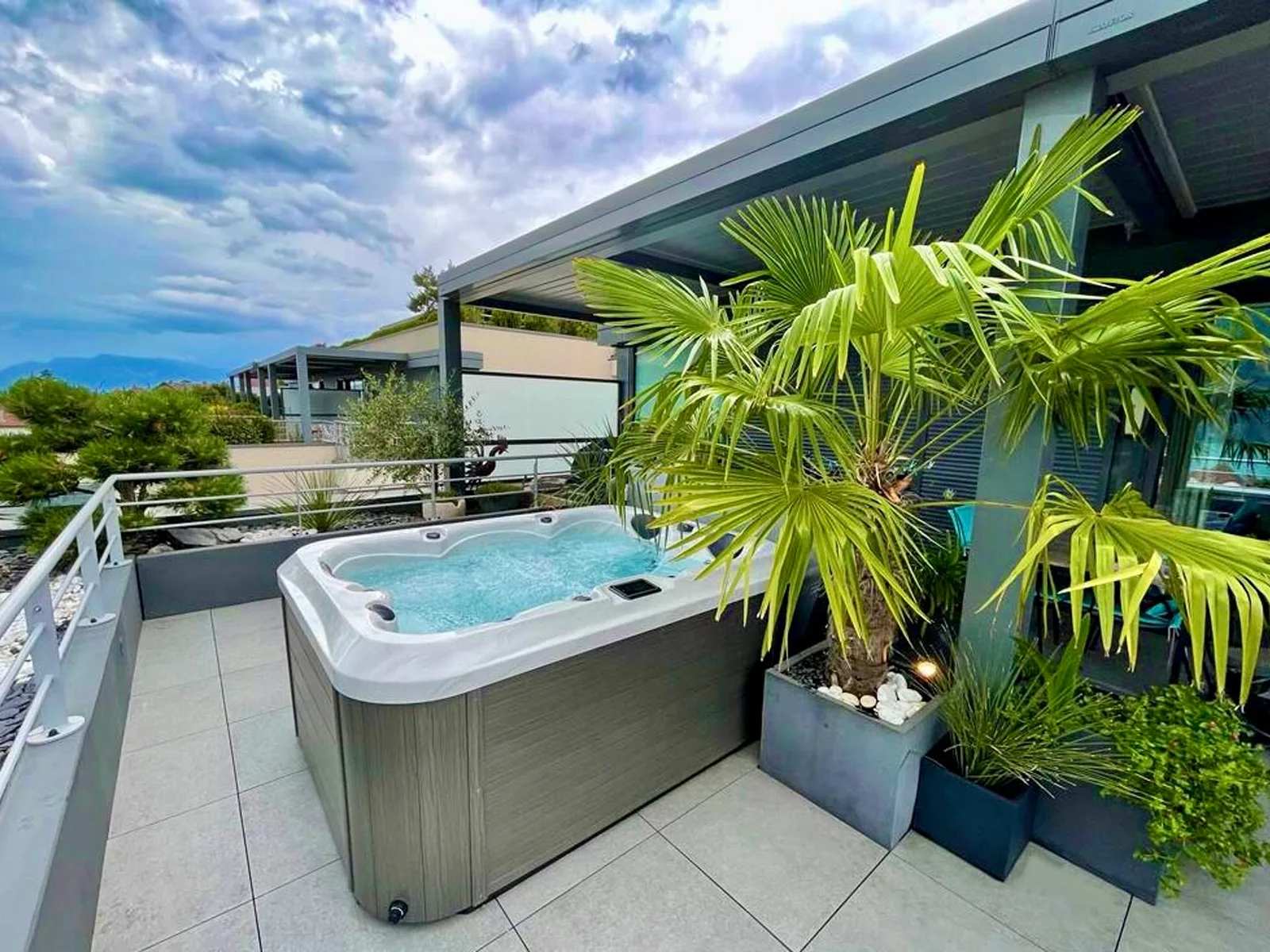 Hot tub on a sunny rooftop terrace with palms