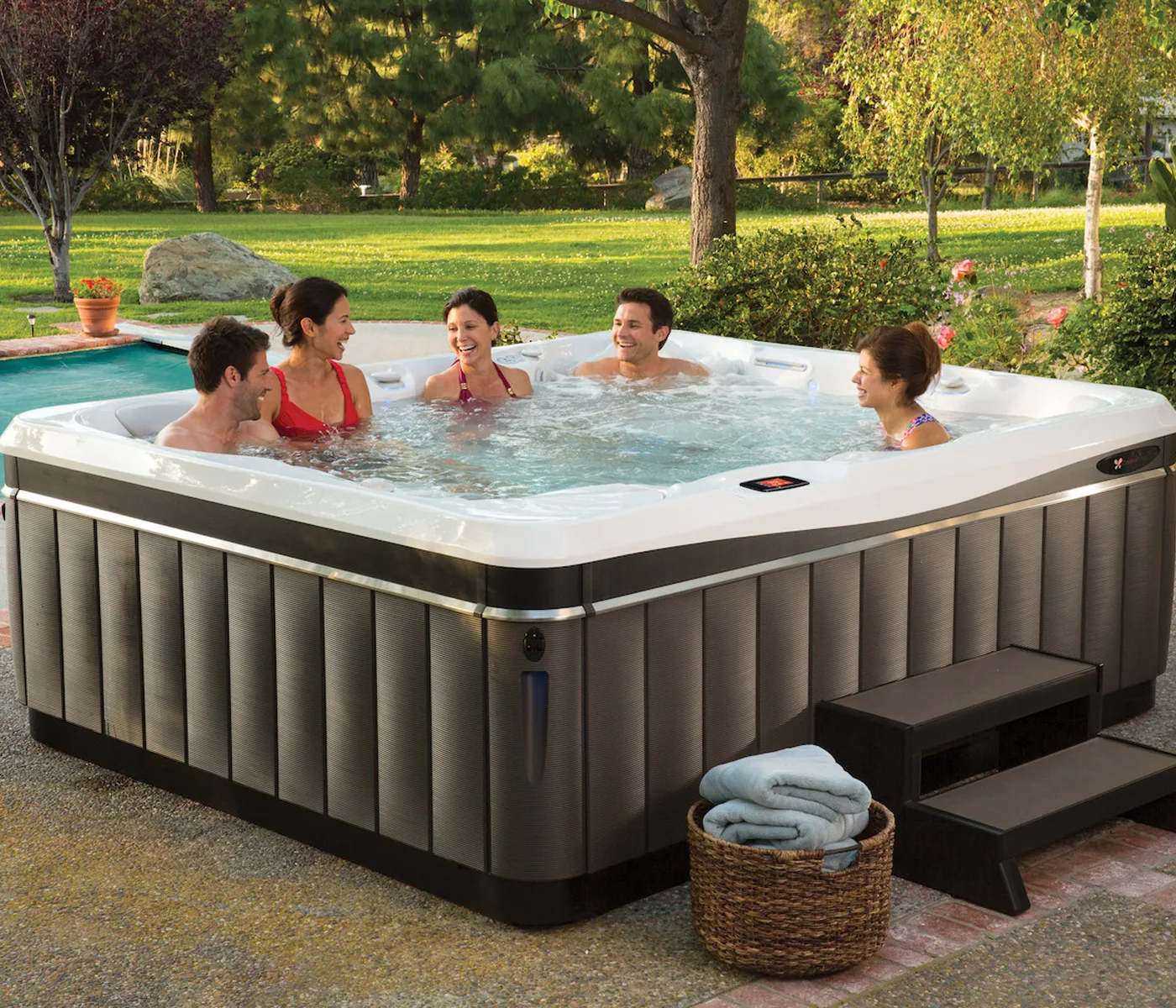 Friends enjoying a Caldera hot tub in a sunny backyard
