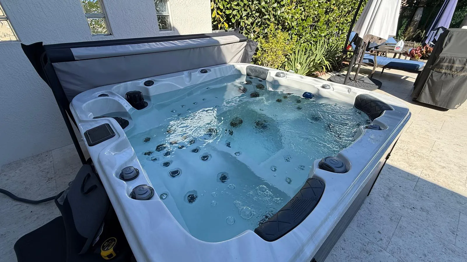 Be Well O578C hot tub on a pool patio in Boynton Beach