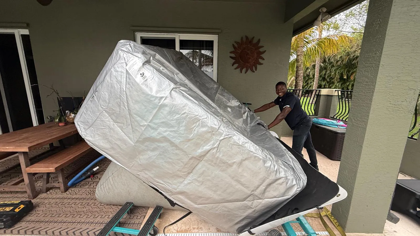 Hot tub being lowered onto an air cushion under the patio roof