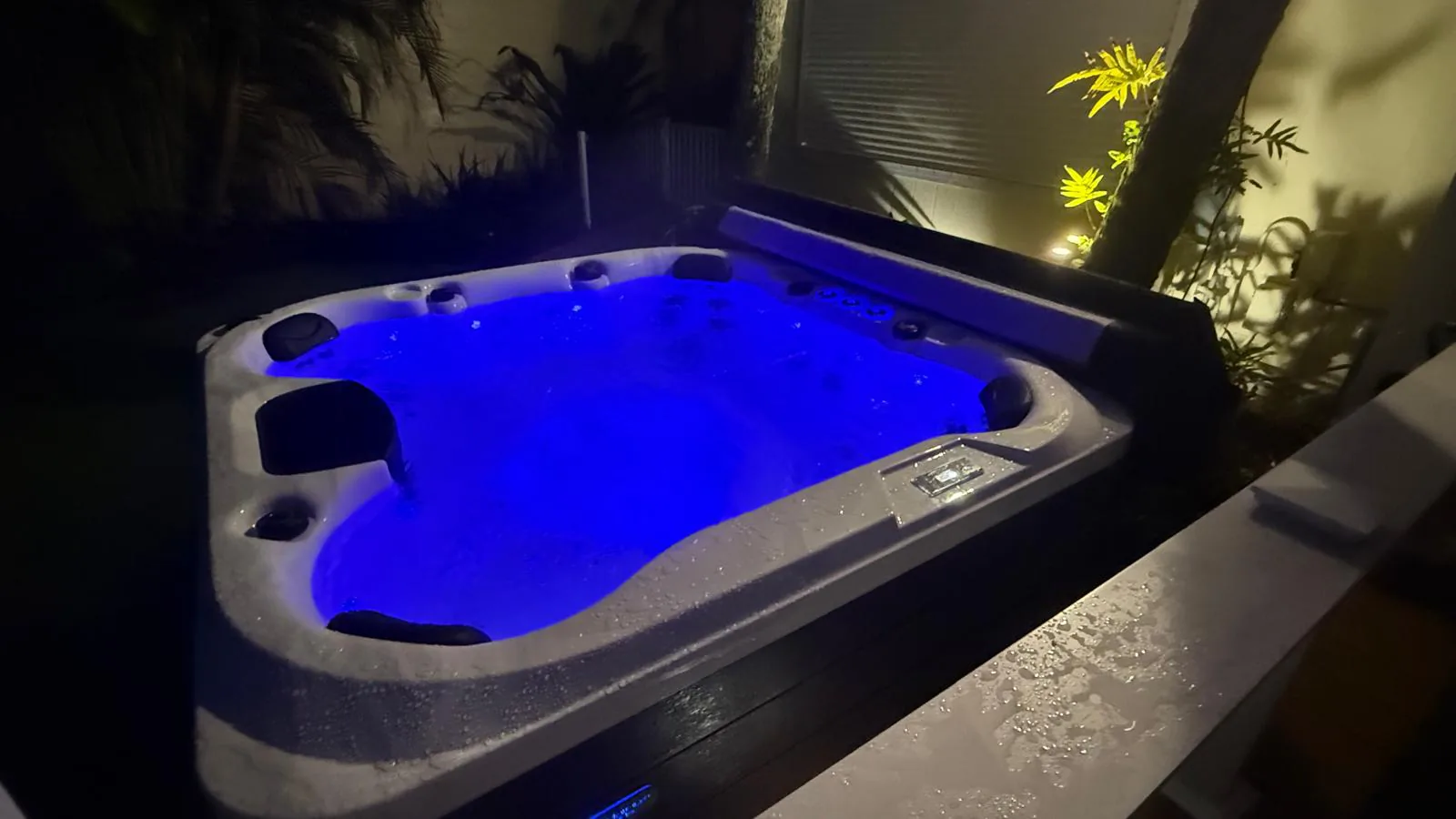 The same hot tub lit blue from inside at night