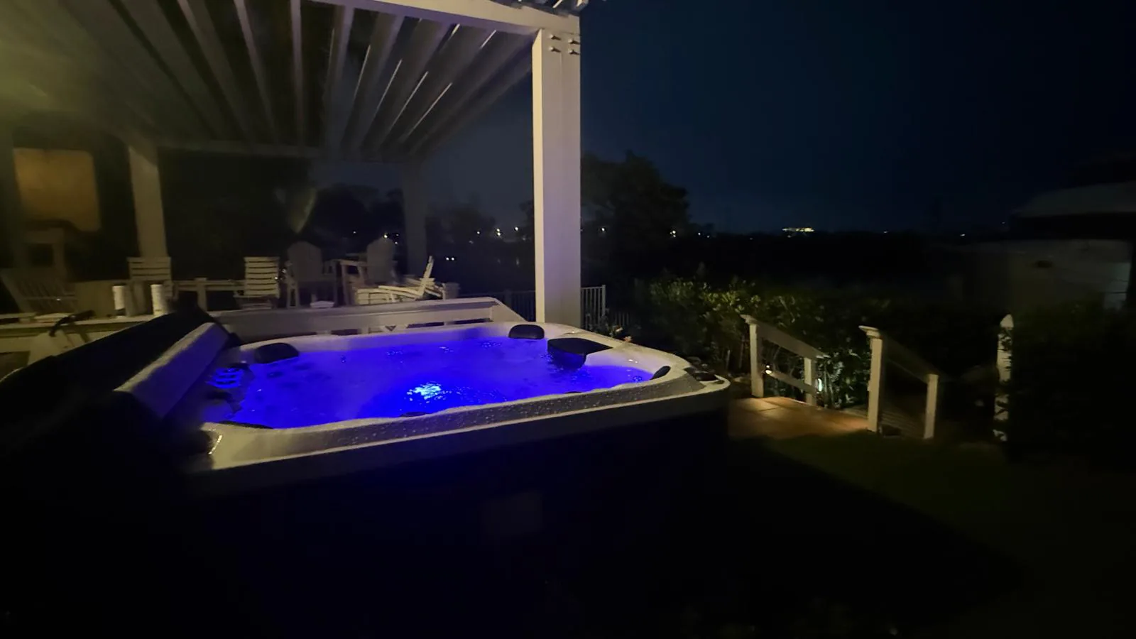 Platinum Reims lit blue at night beside the pergola