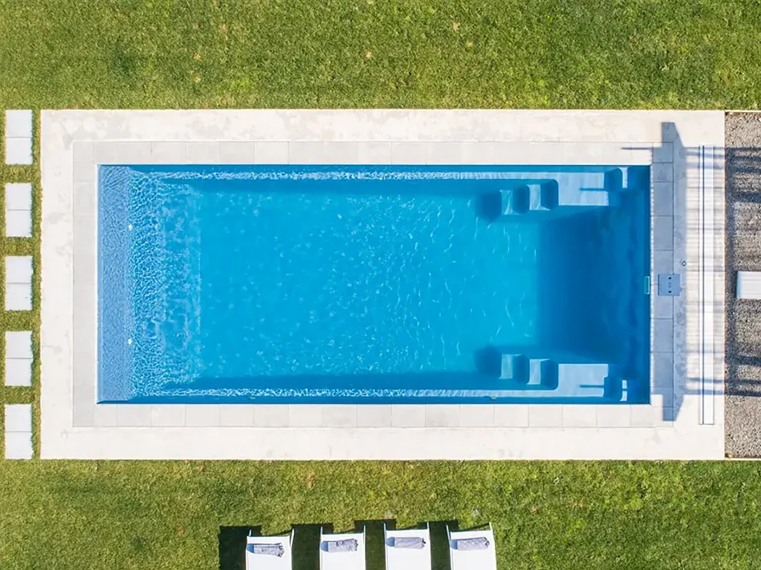 Overhead view of a rectangular fiberglass pool in a lawn