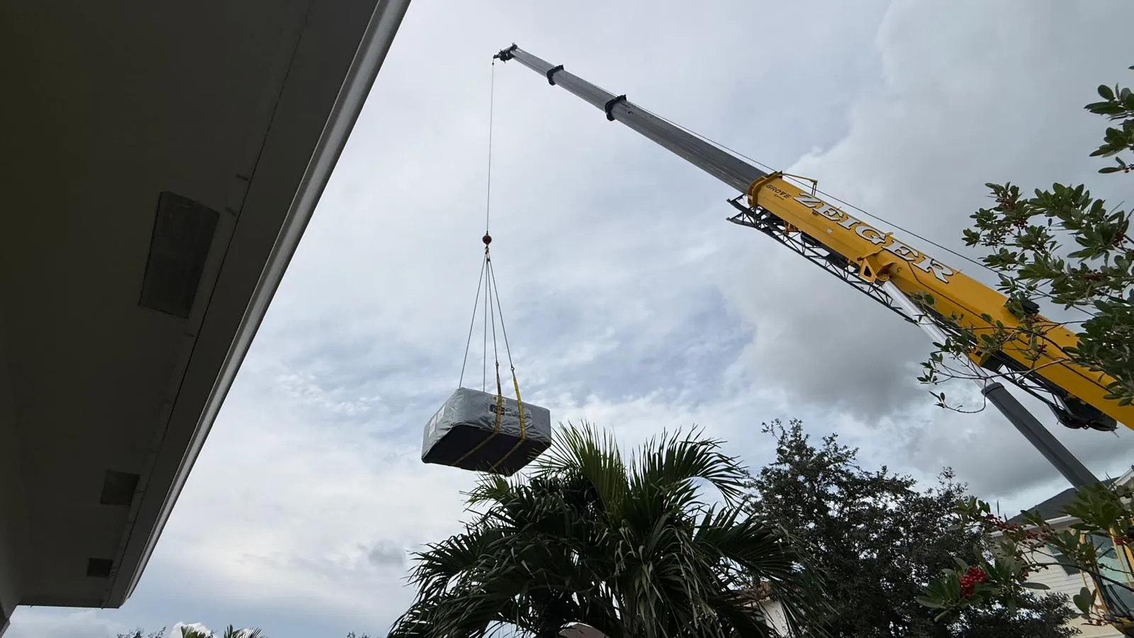 The same hot tub hanging from the crane on its way to the backyard