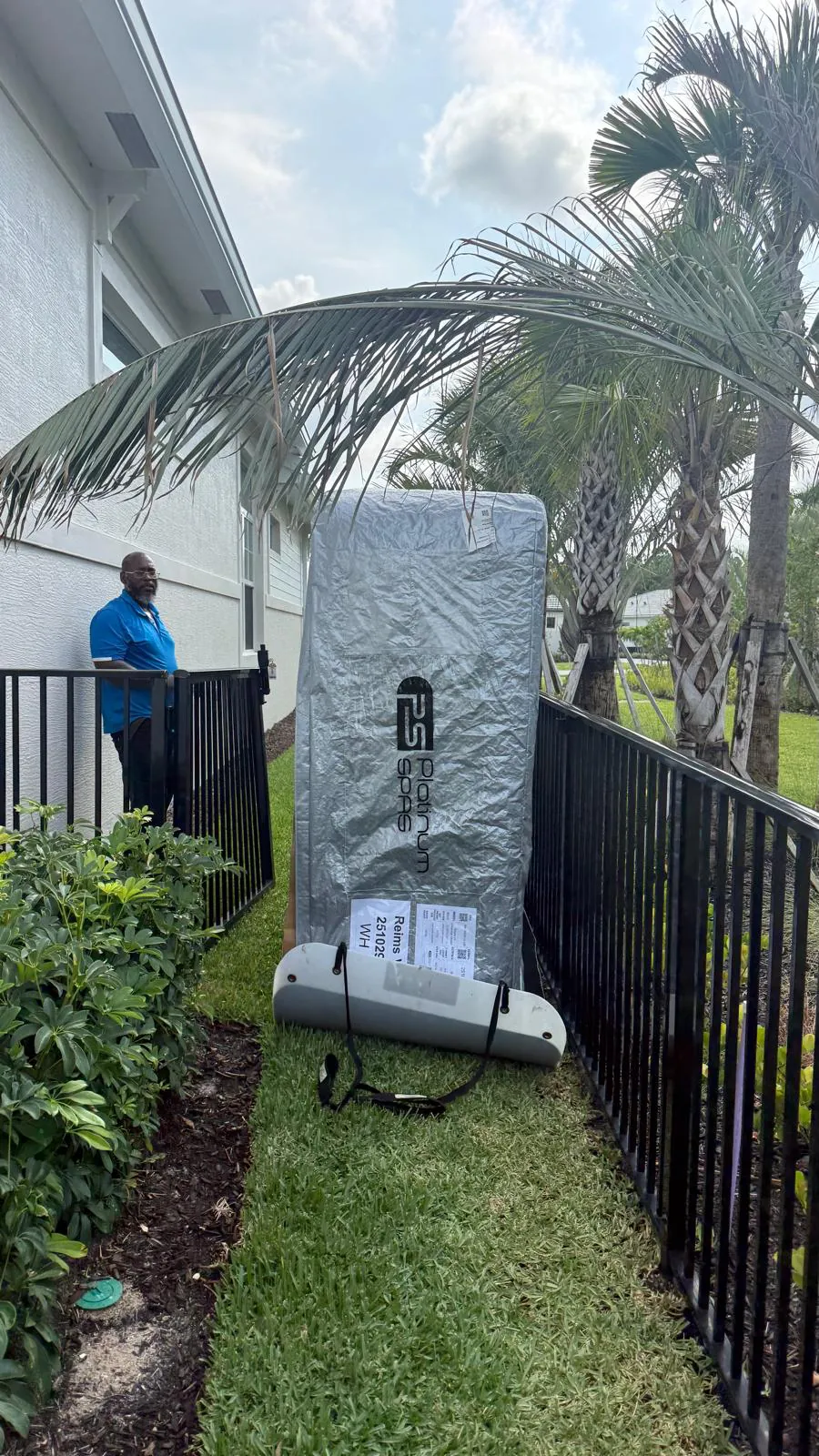 Hot tub on its side passing a fence gate