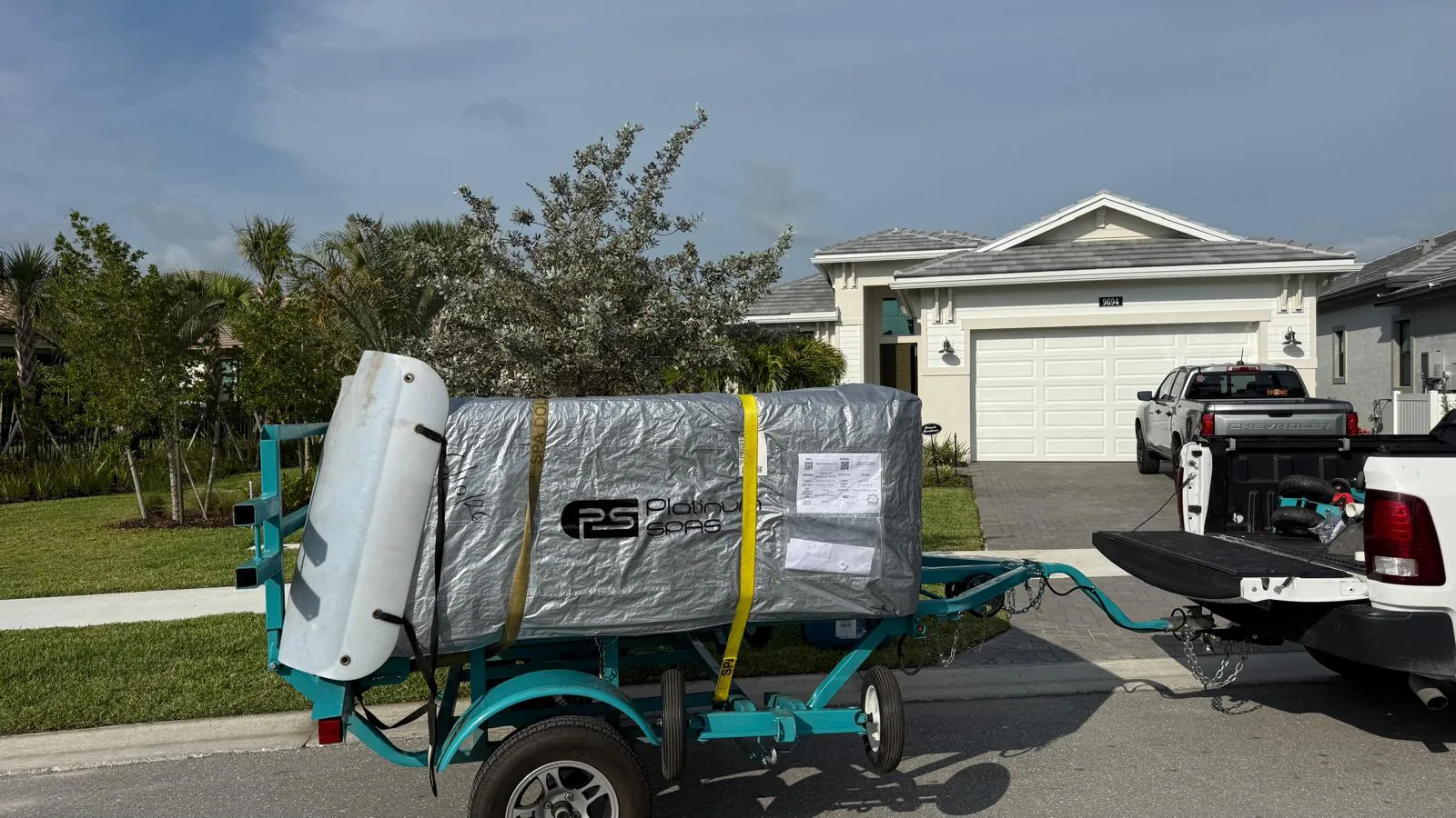 The same hot tub arriving wrapped on a spa trailer