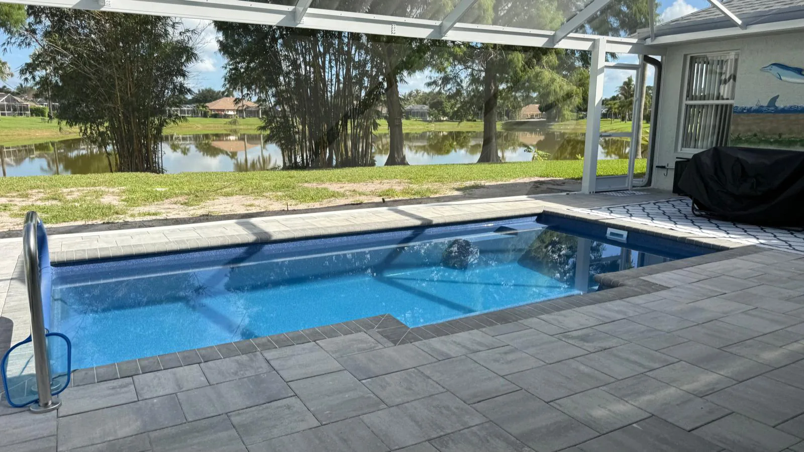 Finished ocean blue Tuscan 11.20 pool with a lake view in Port St. Lucie, FL