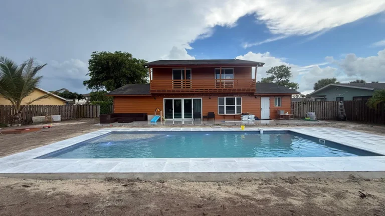 Finished fiberglass pool with coping, seen from the far end of the yard