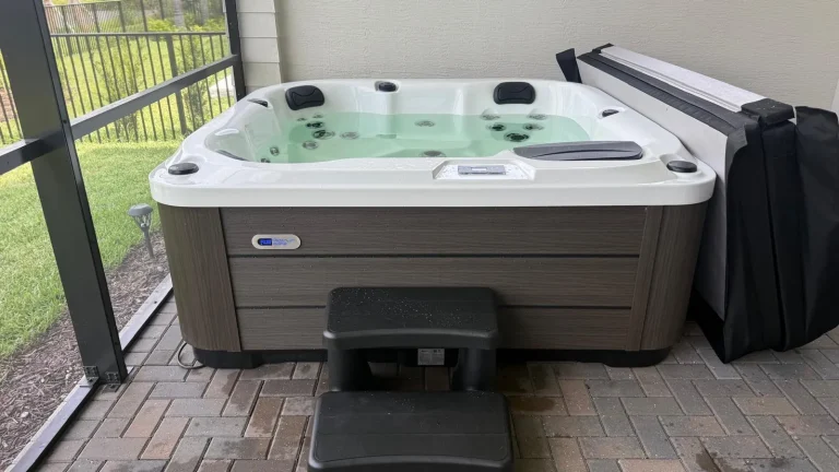 Hot tub installed on a screened patio with steps