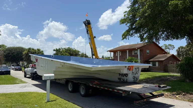 Fiberglass pool shell arriving on a trailer