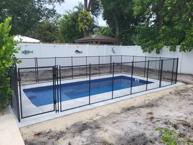 Compact fiberglass pool, fenced and filled