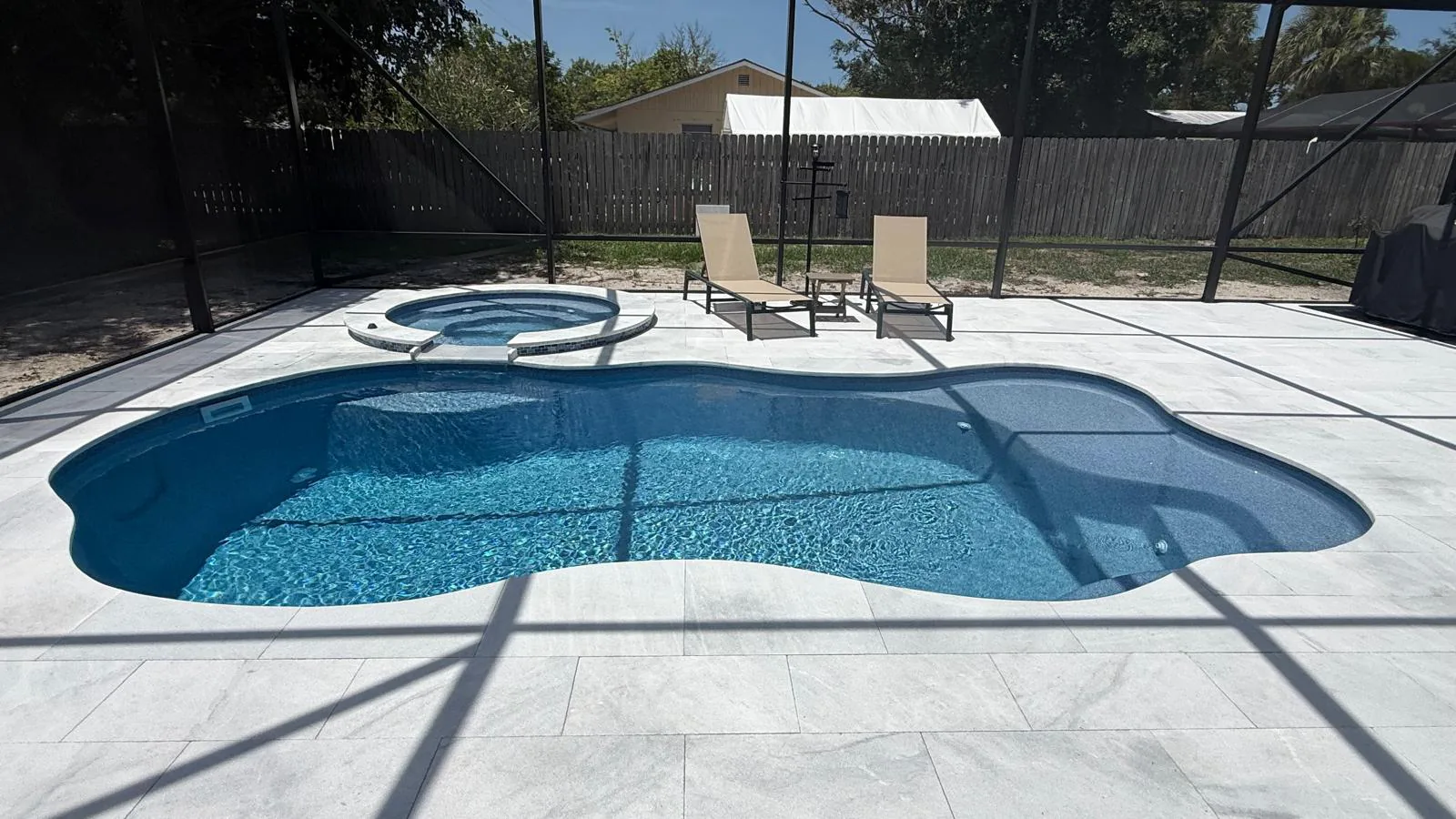Finished Pleasant Cove pool and Shasta spa inside a black screen enclosure in Stuart, FL