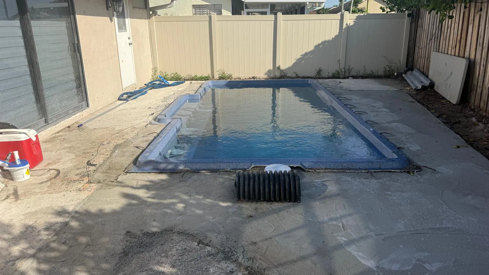 Filled sapphire blue pool set into the concrete deck