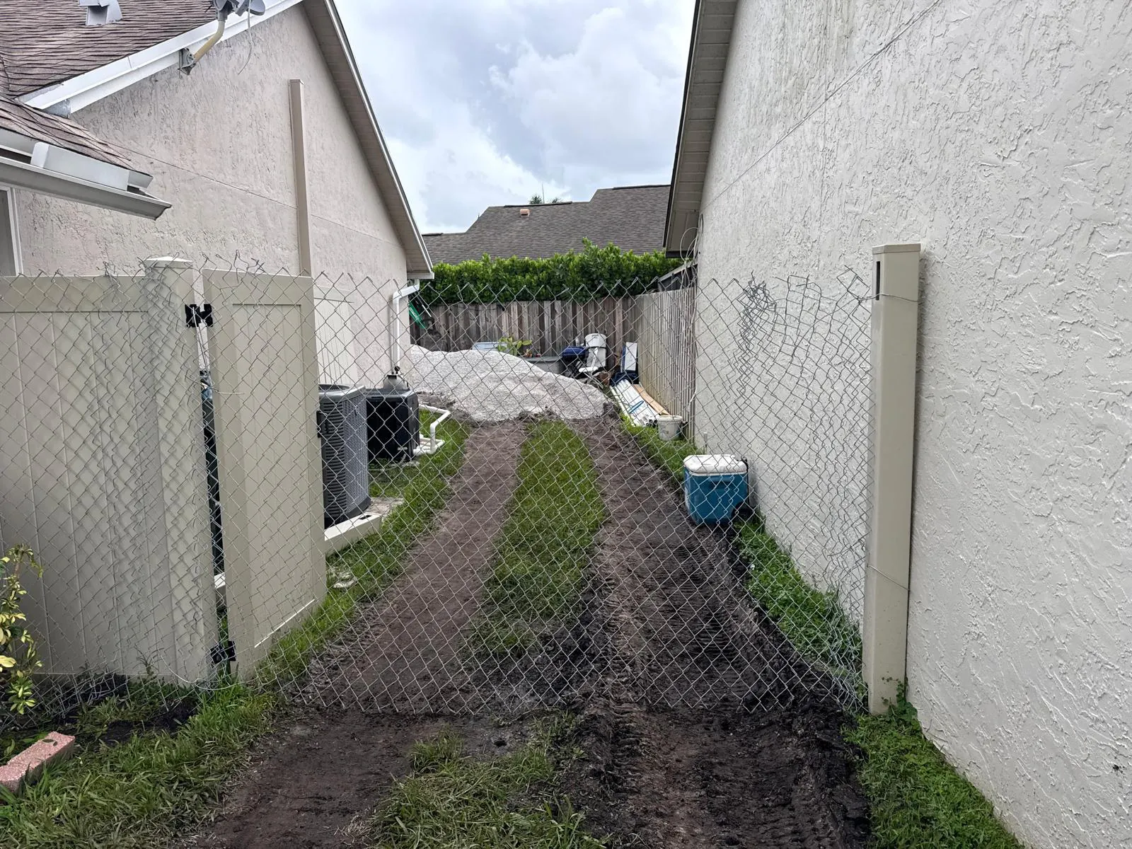 Side yard with machine tracks leading to the backyard